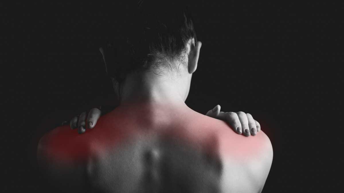 Back of woman rubbing her shoulders with red showing muscle pain